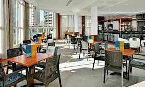 Restaurang med bord och stolar på ett ljust golv. (AI-genererad text)