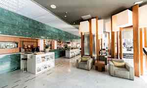 En hotellobby med sittgrupper och en receptionsdisk. (AI-genererad text)