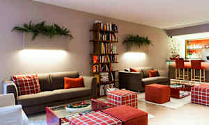 Ett modernt vardagsrum med soffor, en bokhylla och en bardisk i bakgrunden. (AI-genererad text)