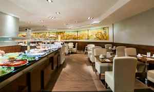 Bild av en bufférestaurang med moderna möbler och ett urval av mat framlagt på en buffédisk. (AI-genererad text)