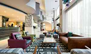 En hotellobby med sittgrupper, en reception och dekorationer. (AI-genererad text)