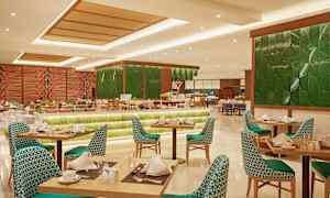 Interiör av en restaurang med dukade bord och stolar samt en buffé med mat i bakgrunden. (AI-genererad text)