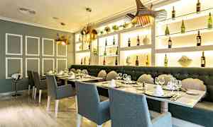 En elegant restaurang med dukade bord, stolar och bakgrund av hyllor med flaskor och dekorationer. (AI-genererad text)