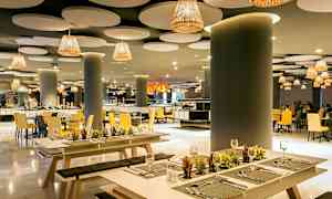 Elegant restaurang med modern inredning, med bänkar och bord dekorerade med små växter. (AI-genererad text)