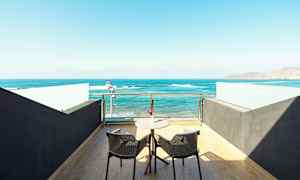 En terrass med två stolar och ett bord med utsikt över havet. (AI-genererad text)