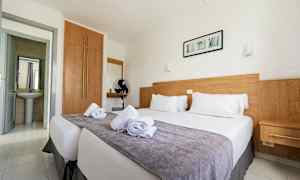 Dubbelrum med en säng, trädetaljer och vita väggar. (AI-genererad text)