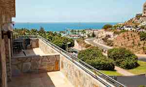 Bild på en balkong med utsikt över havet och landskapet. (AI-genererad text)