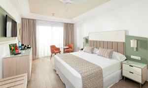 Hotellrum med dubbelsäng, tv, sittgrupp och garderob. (AI-genererad text)