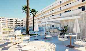 Utomhusområde vid hotell med sittgrupper, parasoller och pool i bakgrunden. (AI-genererad text)