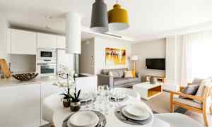 Ett modernt vardagsrum med köksdel, matbord och soffa. (AI-genererad text)
