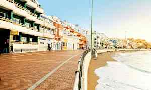 En strandpromenad med färgglada byggnader längs kusten. (AI-genererad text)