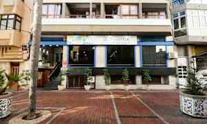 Entrén till ett lägenhetshotell med potted plantor utanför. (AI-genererad text)