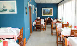 En restaurang med träbord och stolar, blå väggar samt dekorationer och tavlor. (AI-genererad text)