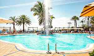 Poolområde med solstolar, parasoller och palmer. (AI-genererad text)