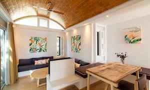 En interiör med träbord, soffa och väggdekorationer med växtmotiv. (AI-genererad text)