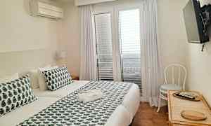 Ett hotellrum med en dubbelsäng och en TV väggmonterad. (AI-genererad text)