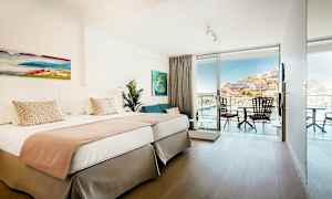 Dubbelrum med ljus inredning och balkong med utsikt. (AI-genererad text)