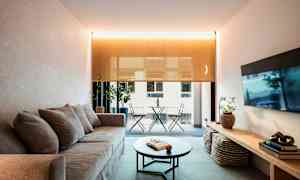 Vardagsrum med soffa, soffbord och utsikt mot balkong. (AI-genererad text)