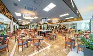 Stort restaurangområde med många bord och stolar. (AI-genererad text)