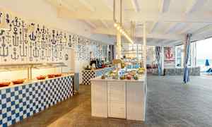 Bild av en bufférestaurang med sjötema, med dukade bord och dekorationer. (AI-genererad text)