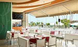 En restaurang med glasväggar som vetter mot en poolområde. (AI-genererad text)