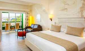 Ett hotellrum med en dubbelsäng, en sittgrupp och en balkong. (AI-genererad text)