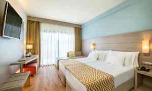 Dubbelrum med modern inredning, ljusa färger och en stor säng. (AI-genererad text)