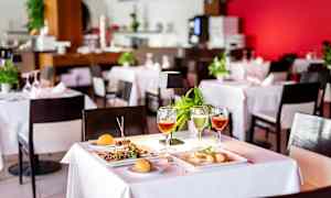 Dukat bord på restaurang med mat och dryck. (AI-genererad text)