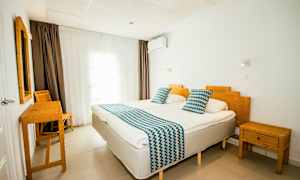 Ett hotellrum med två enkelsängar, bambumöbler och vita väggar. (AI-genererad text)