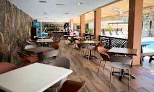 En rymlig uteservering med bord och stolar vid en pool. (AI-genererad text)