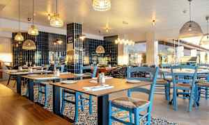 En restaurang med bord och blå stolar. (AI-genererad text)