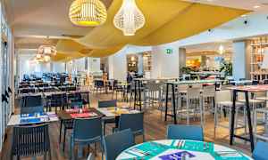 Interiör av en restaurang med uppdukade bord och stolar. (AI-genererad text)