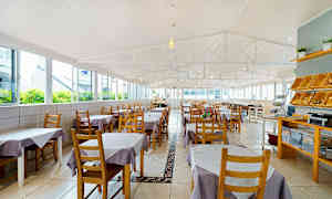 En rymlig restaurang med bord klädda i lila och vita dukar. (AI-genererad text)