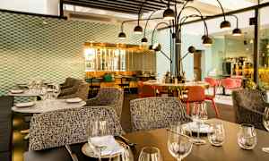 Modern restaurang med dukade bord, stolar och dekorativ belysning. (AI-genererad text)