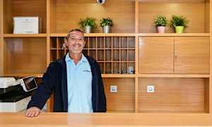 Reception med träinredning, växter och nyckelskåp. (AI-genererad text)