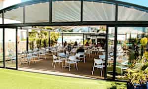 Bild av en restaurang med sittgrupp utomhus och glasväggar. (AI-genererad text)