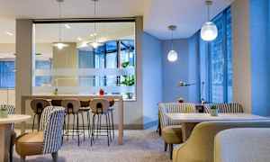 Modernt inredd cafeteriamiljö med bord, stolar och växter. (AI-genererad text)