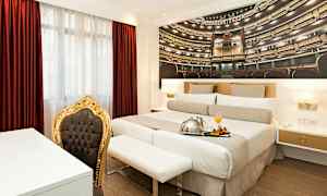 Rum med dubbelsäng, röd gardin, och en stol med guldram. (AI-genererad text)