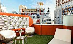 Takterrass med sittmöbler och utsikt över stadens arkitektur. (AI-genererad text)