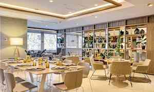 Ett modernt inrett matrum med bord, stolar och dekorativa detaljer. (AI-genererad text)