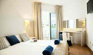 Hotelrum med två enkelsängar, balkong och skrivbord. (AI-genererad text)