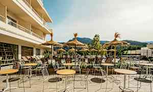 Utomhusområde med bord, stolar och parasoller vid en solig terrass. (AI-genererad text)