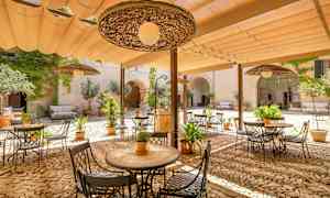 Innergård med utemöbler och växter under ett skärmtak. (AI-genererad text)