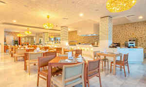 En restaurang med bord och stolar, ljuskronor i taket och en serveringsdisk. (AI-genererad text)