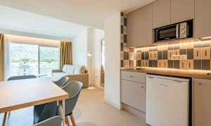 Modernt kök och vardagsrum med utsikt mot balkong och berg. (AI-genererad text)