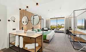 Moderna hotellrum med dubbelsäng, sittmöbler och badrumsdel. (AI-genererad text)