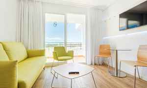 Ett modernt hotellrum med ljusa möbler och sittgrupp. (AI-genererad text)