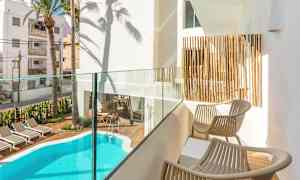 Privat balkong med utsikt över en pool och solstolar. (AI-genererad text)