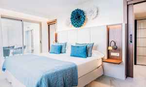 Sovrum med en dubbelsäng och ljus, modern inredning. (AI-genererad text)