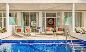 En terrass med solsängar och sittmöbler framför en privat pool. (AI-genererad text)